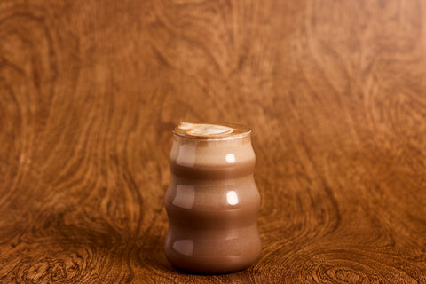 Glass of chocolate milk on a wooden surface
